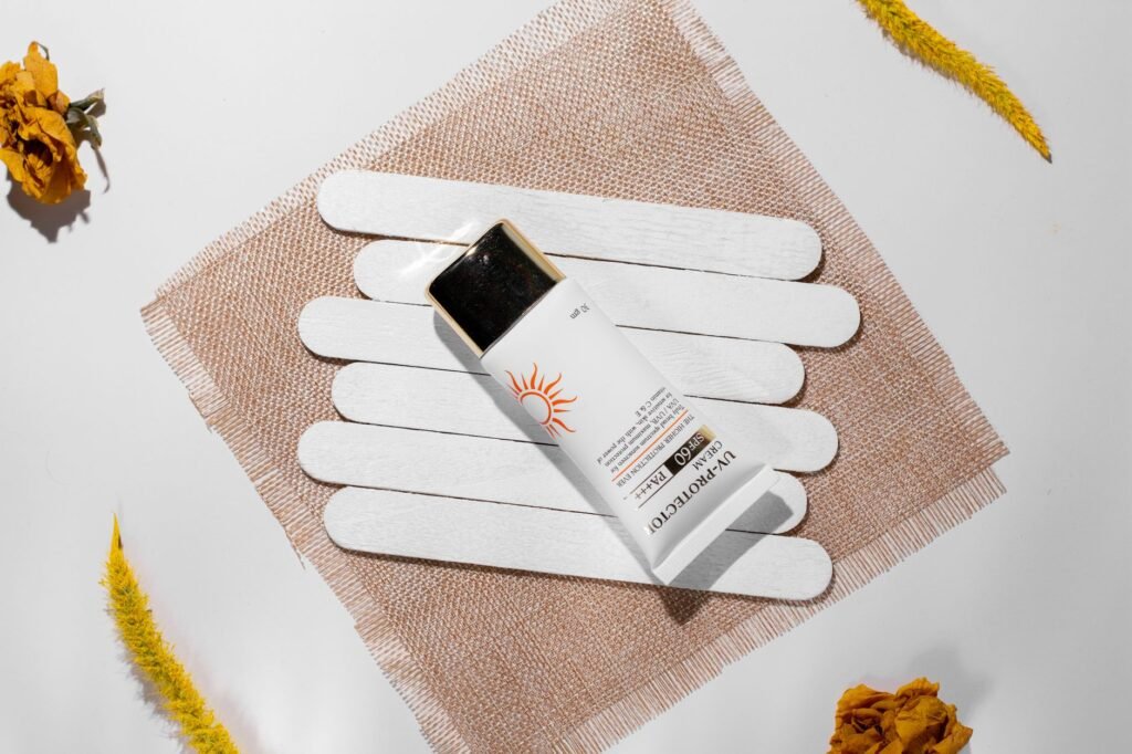 best sunscreen for summer in Pakistan – Minimalist flat lay of sunscreen SPF 60 with natural elements, enhancing beauty care theme.