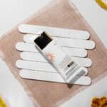 best sunscreen for summer in Pakistan – Minimalist flat lay of sunscreen SPF 60 with natural elements, enhancing beauty care theme.