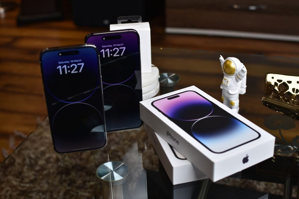 buy iPhone 18 Pro Max from Amazon in Pakistan – Close-up of Apple iPhone 14 Pro Max with astronaut figurine on a reflective surface.