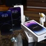buy iPhone 18 Pro Max from Amazon in Pakistan – Close-up of Apple iPhone 14 Pro Max with astronaut figurine on a reflective surface.