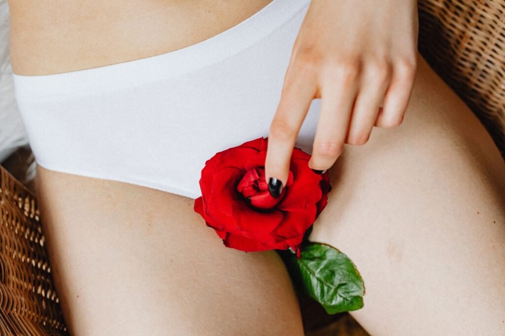 artificial hymen kit in pakistan – Conceptual close-up image featuring a red rose on white underwear, capturing a blend of elegance and subtlety.