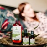dooz 14000 spray price in pakistan – CBD hemp oil pain relief products displayed indoors with a relaxed person in the background.