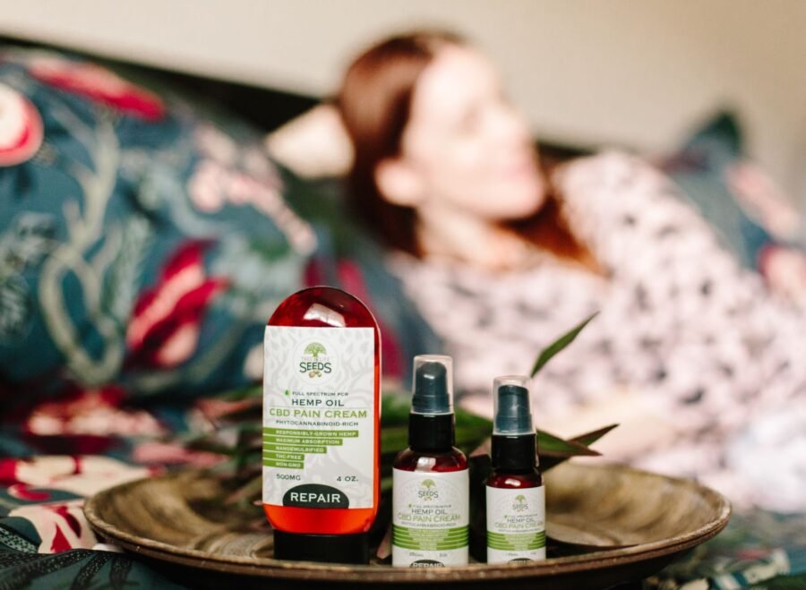dooz 14000 spray price in pakistan – CBD hemp oil pain relief products displayed indoors with a relaxed person in the background.