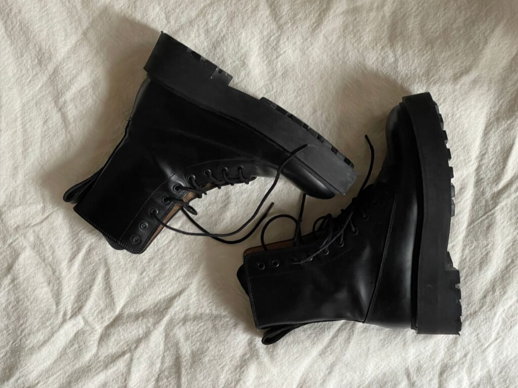 pak army shoes vs us tactical boots – Pair of black combat boots stylishly arranged on white fabric background.