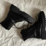 pak army shoes vs us tactical boots – Pair of black combat boots stylishly arranged on white fabric background.