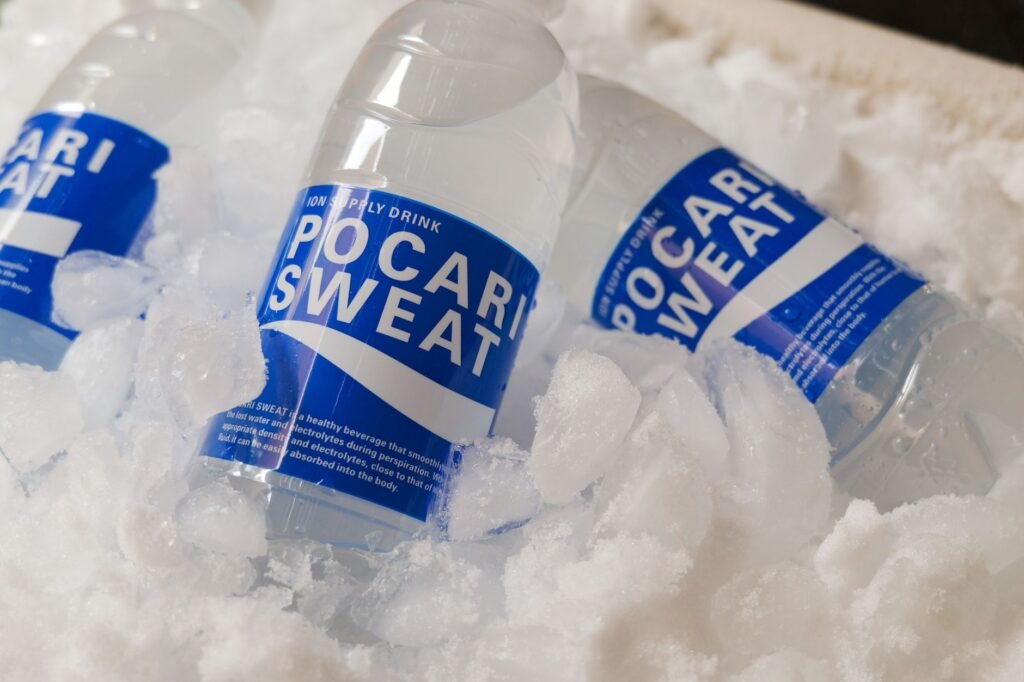 US electrolyte drinks for cricket fans Pakistan – Refreshing Pocari Sweat bottles embedded in ice, showcasing hydration and cooling.