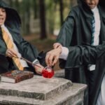 harry potter costume pakistan – Three children in wizard costumes play with potions and wands in a fantasy-themed setting outdoors.