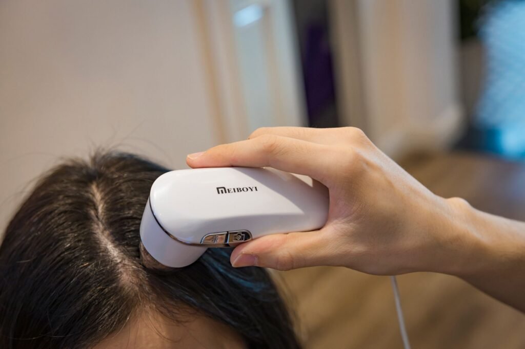 vein viewer price in pakistan – Close-up of a handheld device examining a person's scalp indoors.