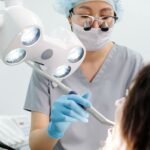 dental loupes price in pakistan – Dentist using tools and lights during a dental examination procedure in a modern clinic.