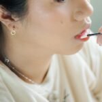 lip palette in pakistan – Close-up of a woman applying makeup with a brush, showcasing her lips.