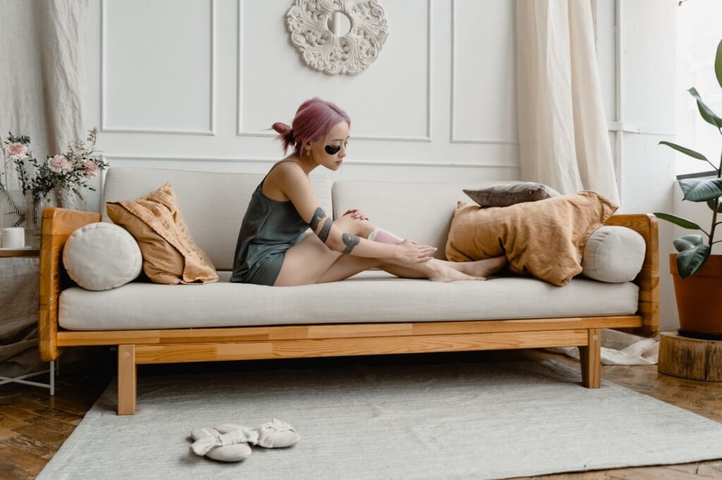 professional wax heater – An adult woman waxing her legs at home, showcasing a self-care beauty routine.