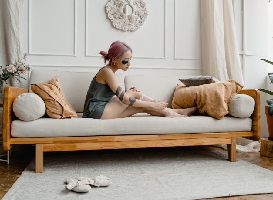 professional wax heater – An adult woman waxing her legs at home, showcasing a self-care beauty routine.