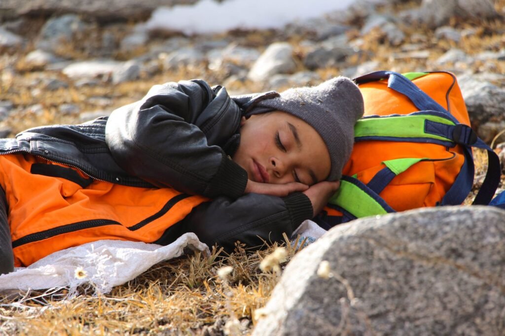 sleeping bag pakistan – A child peacefully sleeping outdoors during a hiking adventure in Pakistan.