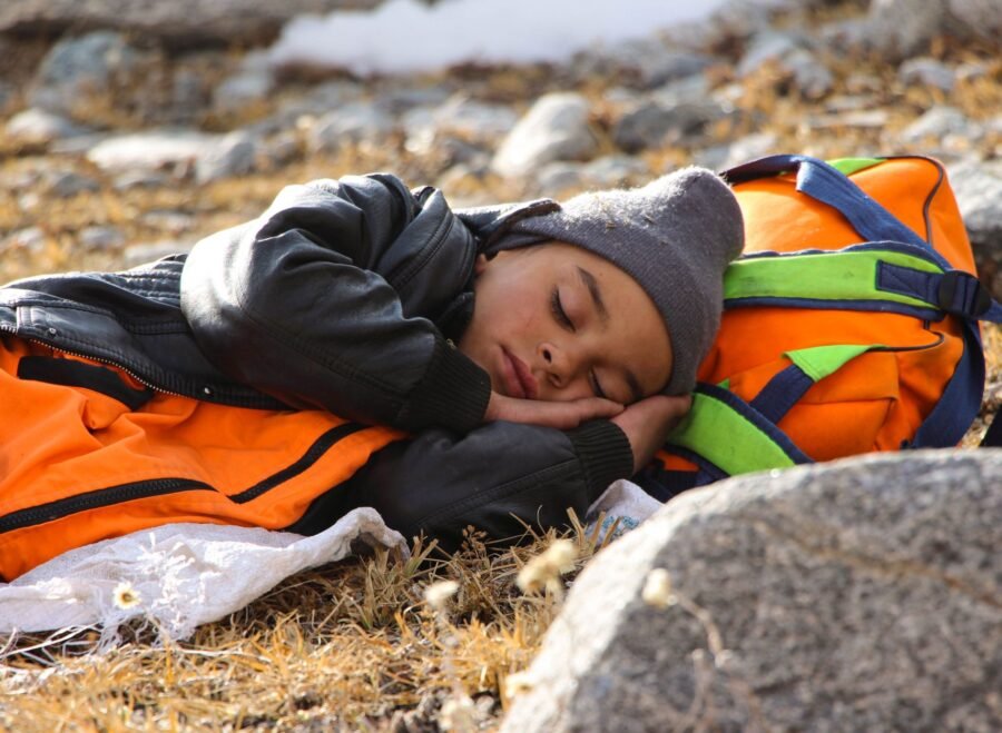 sleeping bag pakistan – A child peacefully sleeping outdoors during a hiking adventure in Pakistan.