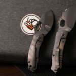 tactical knives pakistan – Two tactical knives resting on dark fabric with a bee patch, highlighting knife design details.