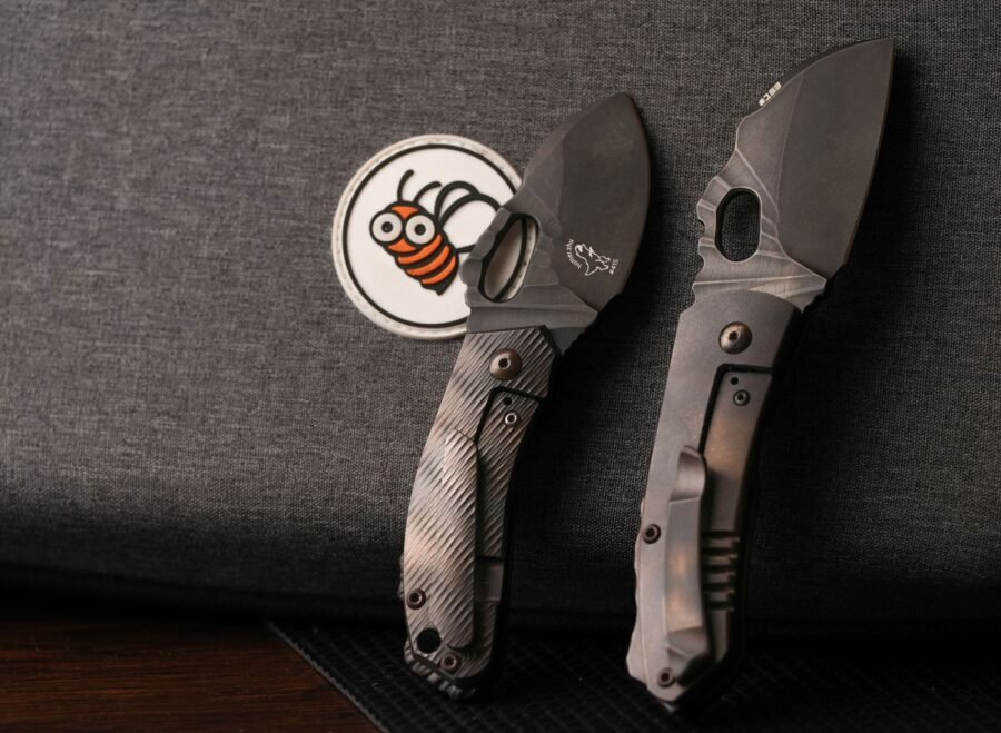 tactical knives pakistan – Two tactical knives resting on dark fabric with a bee patch, highlighting knife design details.